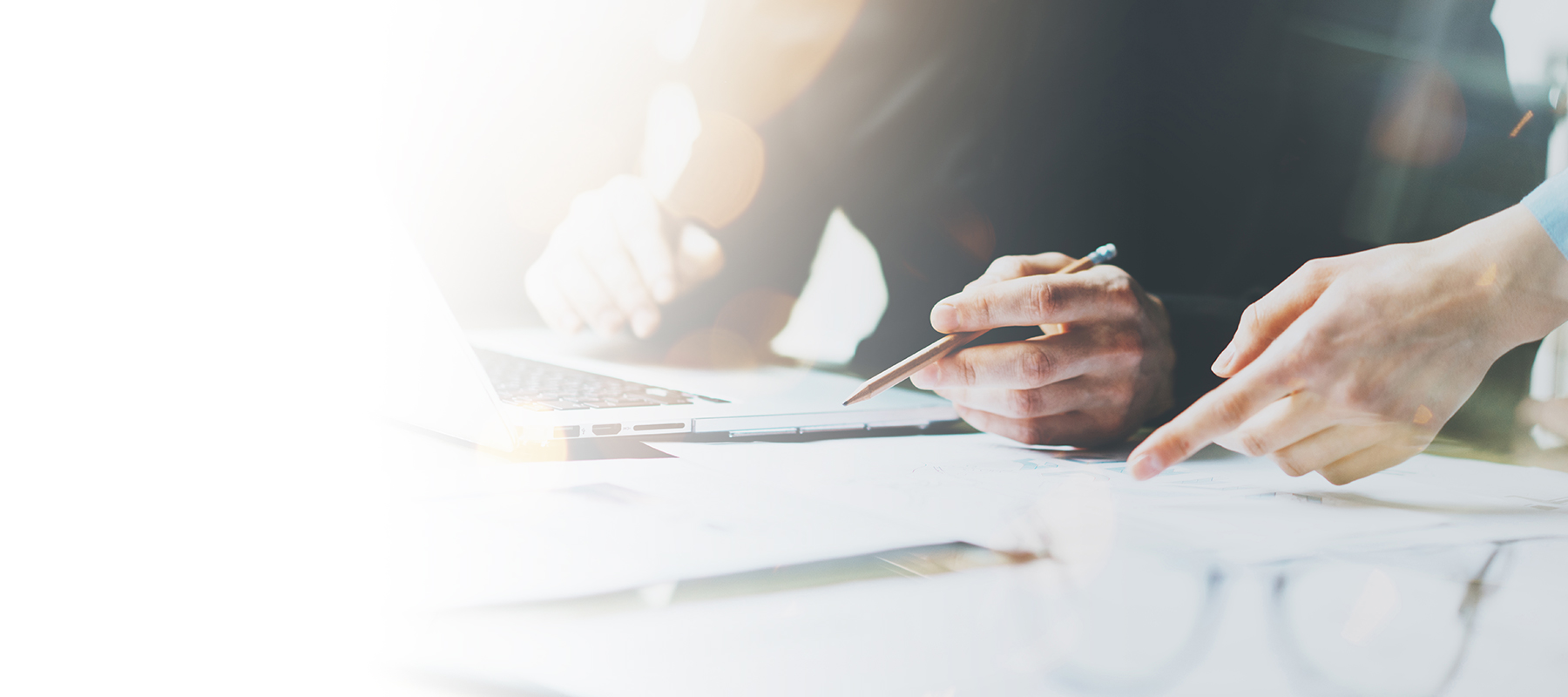 Two colleagues at a work station with a laptop