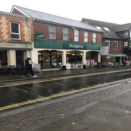 Pedestrian walking in front of street shops