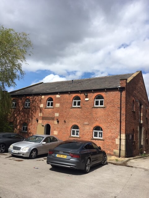 Brick Building With Cars Parked Beside