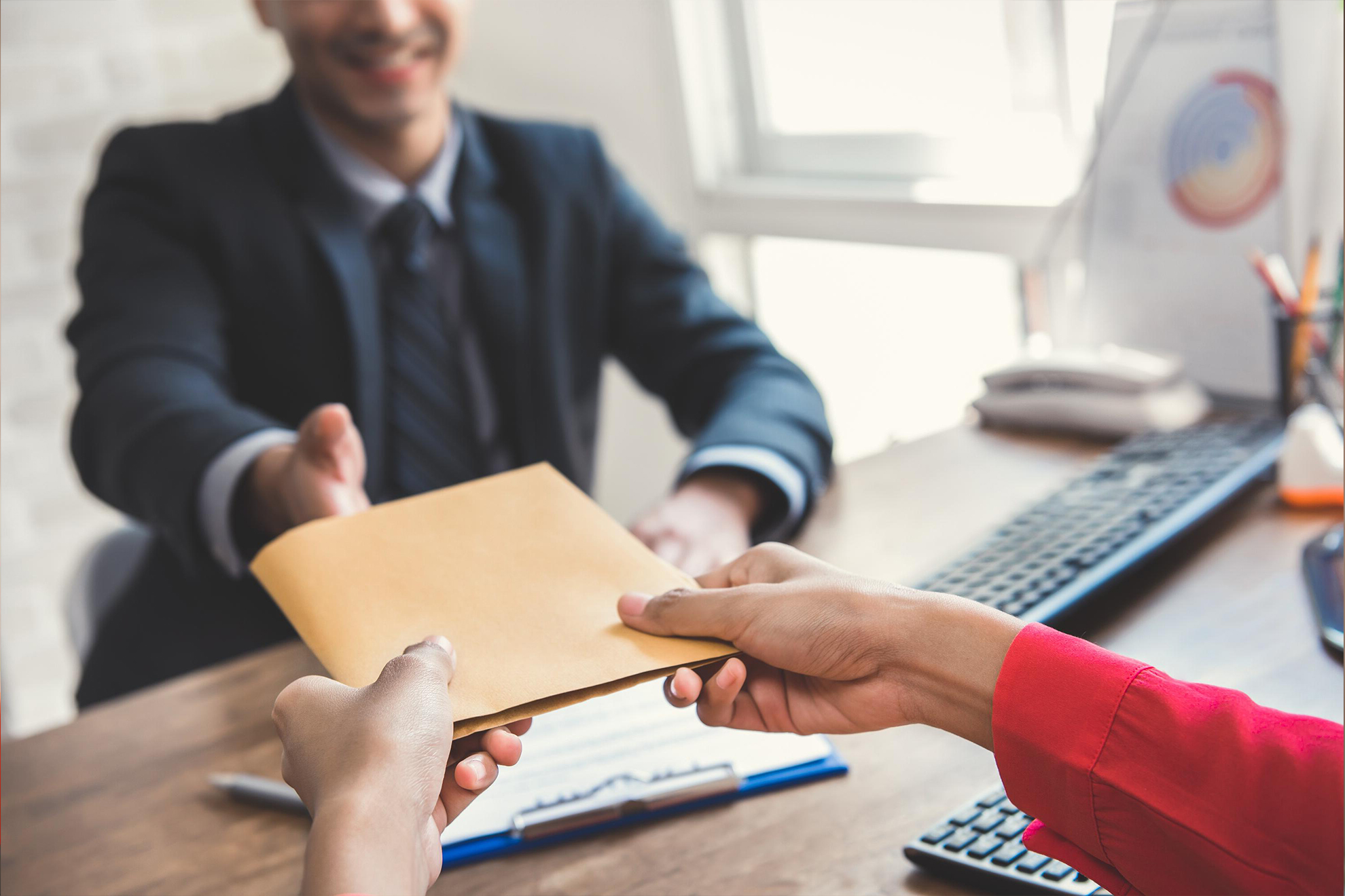 Client handing envelope to a claims employee