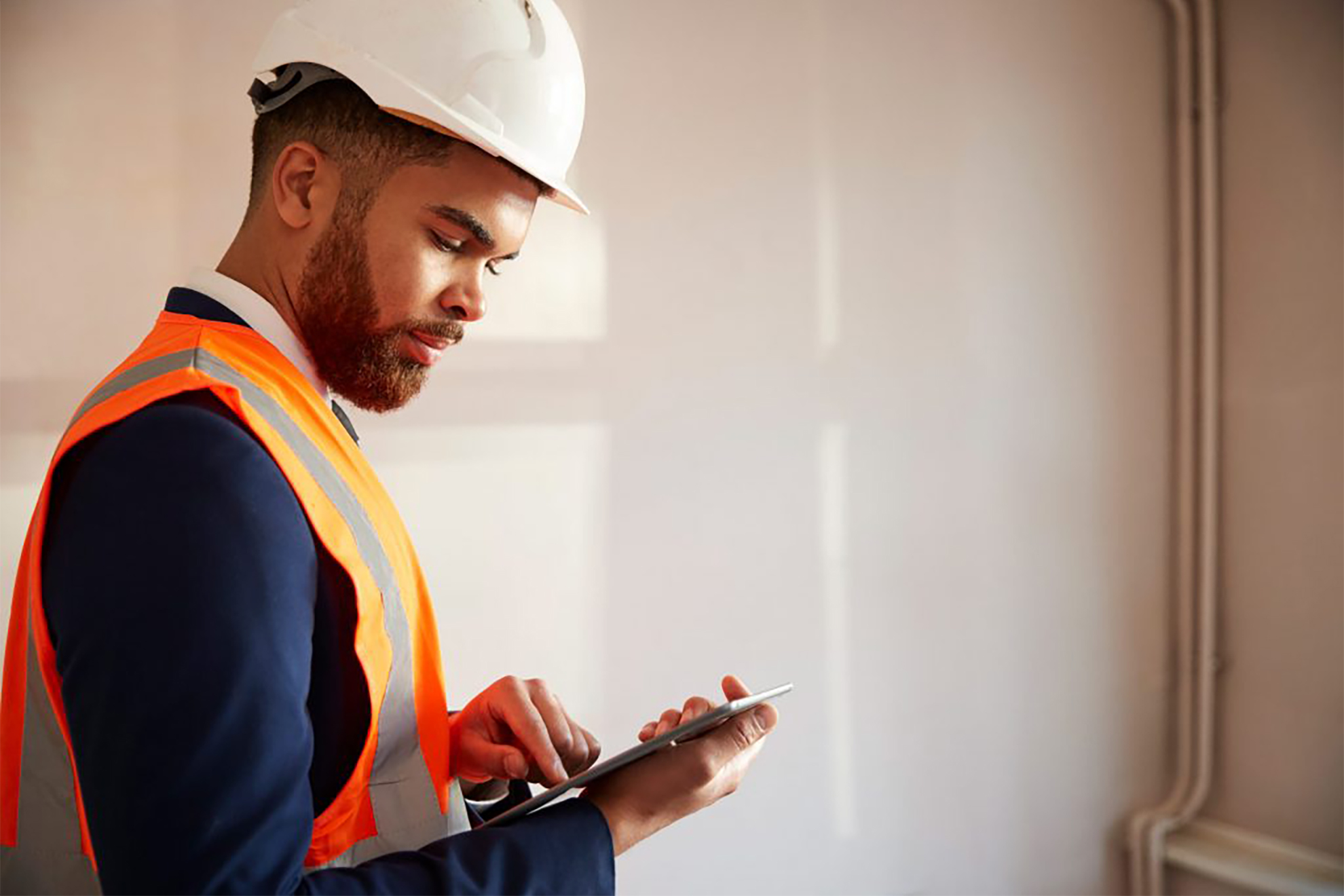 Surveyor inspecting a room while holding a tablet device.