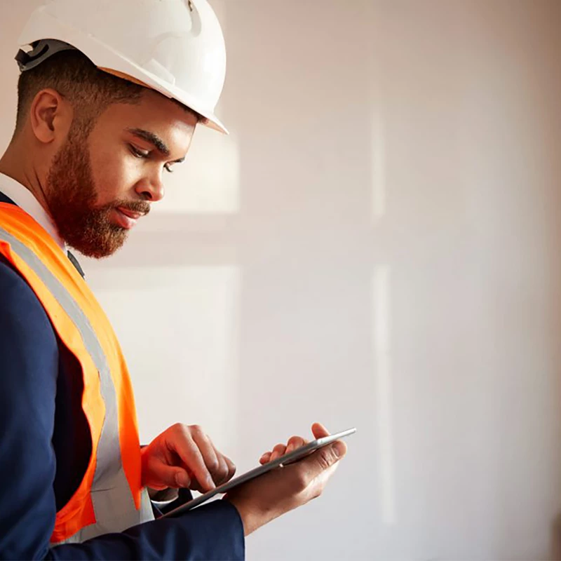 Surveyor inspecting a room while holding a tablet device.