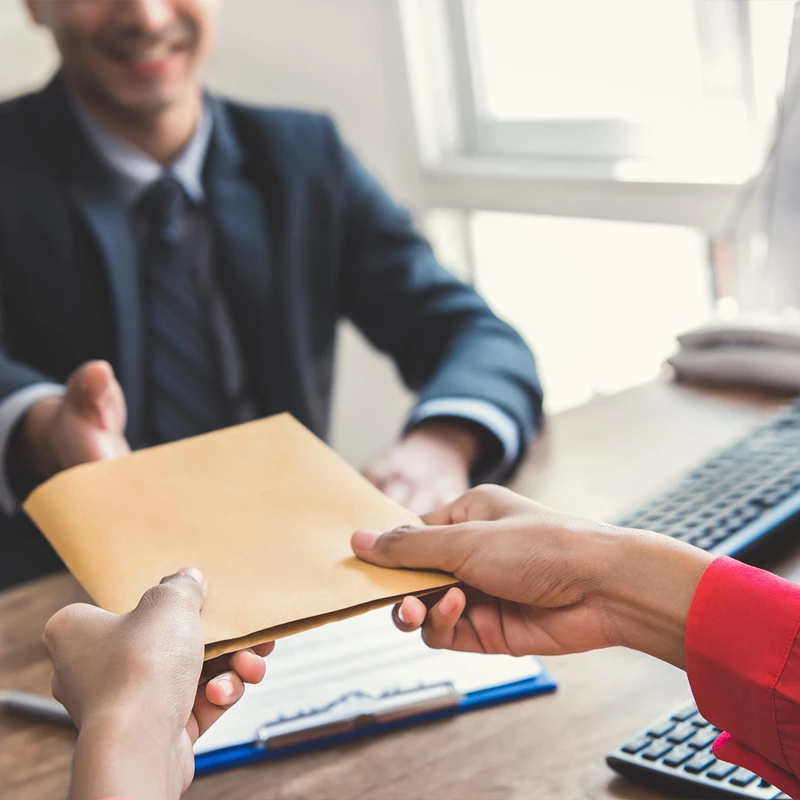 Client handing envelope to a claims employee
